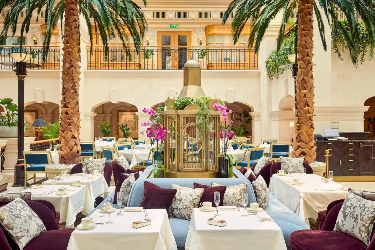 Restaurant with tables and palm trees at The Landmark London on Marylebone Road